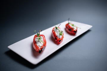 closeup of bulgarian peppers stuffed with cottage cheese on black background