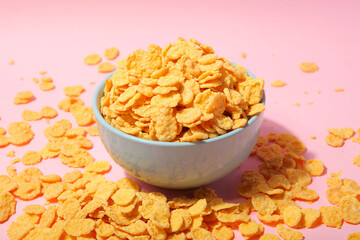 Delicious cornflakes in a plate against colored background. 