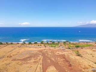 Aerial view of beach and ocean with waves in the island of Maui, Hawaii. Launiupoko State Beach during hot summer.