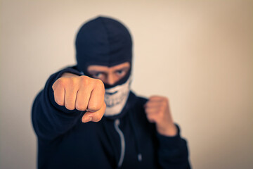 Fist punch, a man in a black and white mask giving a punch