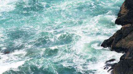Waves break on rocky shore (texture) © Bailey Vianello