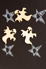 halloween theme with wooden shapes and white stars arranged on a black paper background