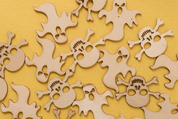 halloween themed wooden shapes (scary monsters and skull and crossbones) on a yellow background