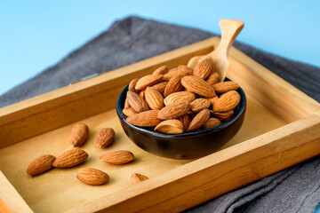 Almonds nuts on bowl with on wooden container / Roasted almond for snack