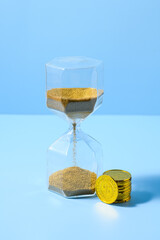 Hourglass and pile of gold coins, time is money, concept: investment, deposit, saving