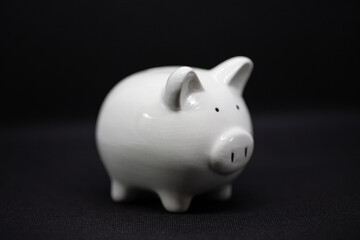 White piggy Bank on black background for saving money wealth and finance concept and copy space.