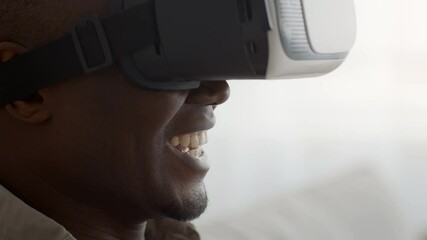 African Man Experiencing Virtual Reality Wearing VR Headset Indoors, Cropped