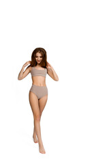 Young, fit and beautiful slender girl in gray sports underwear posing on a white background. Health care, diet, sport and fitness concept 