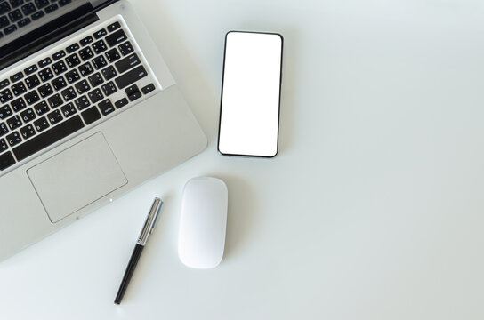 Top view mock up smartphone with mouse computer latop and pen.Copy space flatlay.
