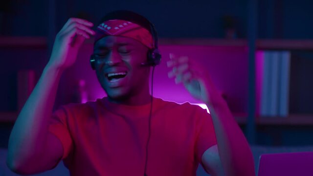 Emotional African Man Talking Via Video Call Wearing Headset Indoor