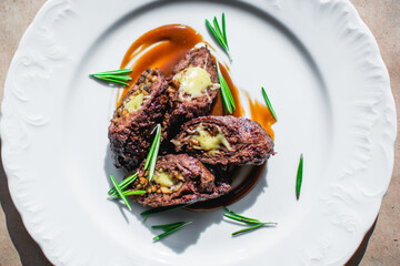 Delicious roast pork according to Italian culinary traditions on a white grater. Close-up