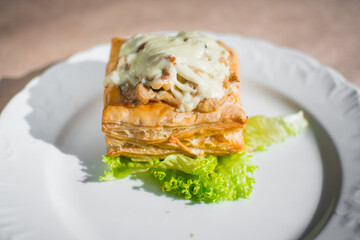 Asian food. Samsa with sauce and herbs on a white plate 