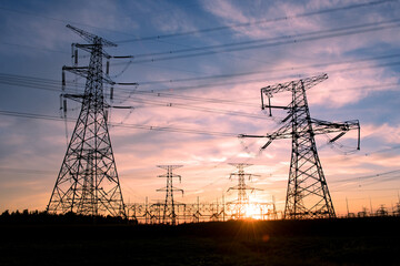 A silhouette of an electric tower against a beautiful sunset background