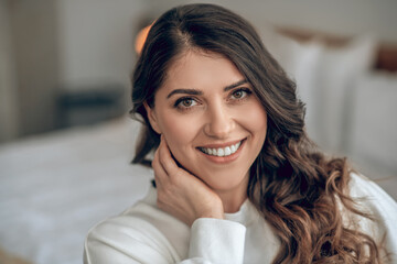Pretty young long-haired woman in a white blouse smiling nicely