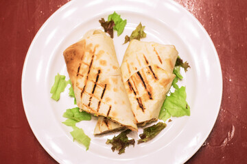 Shawarma with meat, sauce, tomatoes, cheese, herbs and garlic 