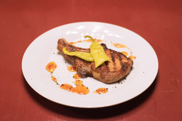 Piece of meat with pepper on a white plate 