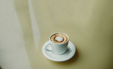 cup of coffee with white sugar on the top on the table