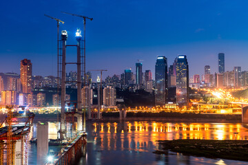 cityscape and skyline of downtown near water of chongqing at night