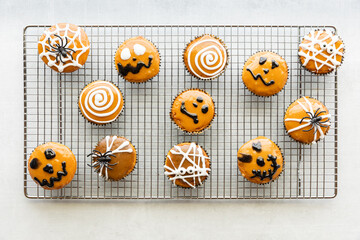 Top down view of Halloween decorated cupcakes on a cooling rack.