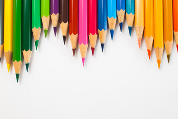 Top view Colored pencils. Different colors are placed alternately on a gray background. Ready to use in school supplies, offices, packaging, and advertising