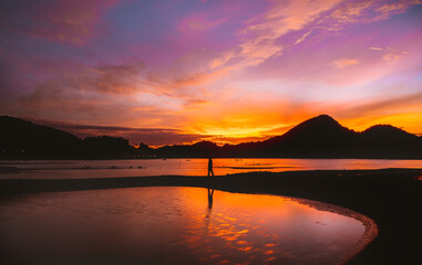 Silhouette fisherman and mountain at big water reservoir with twilight sky background.  
