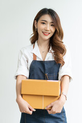 Happy Asian woman holding package parcel box on white background, Delivery courier and shipping service concept.