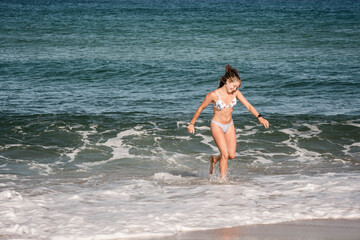 Fototapeta premium gorgeous young woman in bikini by the ocean