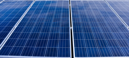 Obraz premium Photovoltaic roof with reflection of the Sun and clouds on the surface.