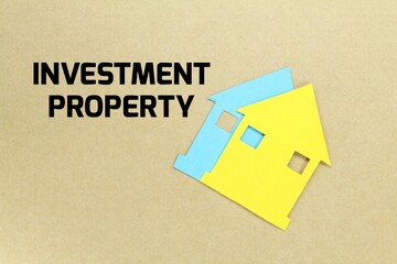 paper house with the word investment property. Real estate concept