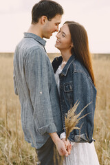 Happy couple in love in wheat field at sunset