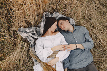 Obraz premium Happy couple in love in wheat field at sunset