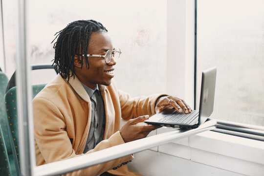 Young African businessman standing on a bus - Powered by Adobe