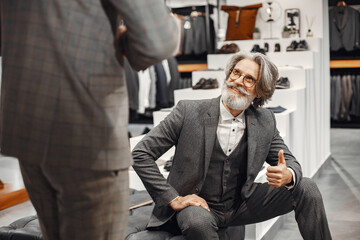 Fototapeta na wymiar Senior man choosing a new suit in a store
