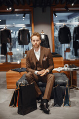 Handsome man with beard choosing shoes in a shop