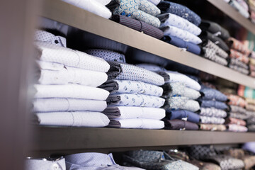 Assortment of shirts in menswear clothing store for selling, textile industry concept