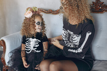 Mother with daughter in a halloween costume and makeup