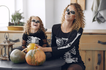 Mother with daughter in a halloween costume and makeup
