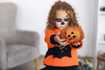 A little girl with halloween makeup on her face at home