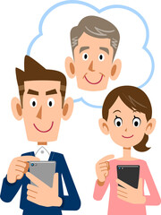 携帯電話で遠方の父親を見守る夫婦
