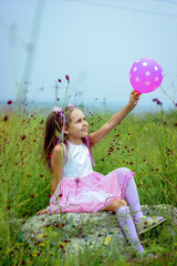 A girl with a ball, a girl in a field,balloon, woman, child, balloons, fun, summer, field, happiness, sky, party, beauty, birthday, joy, grass, holding, people, freedom, smiling, person, dress, nature