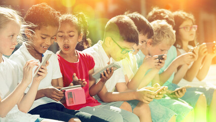 Children are playing on smartphone in the playground. High quality photo