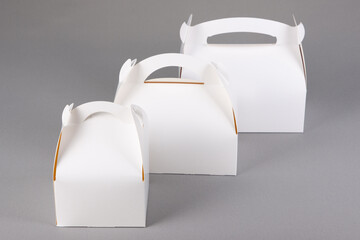 Take away three blank mockup white empty to go cake box on grey background isolated