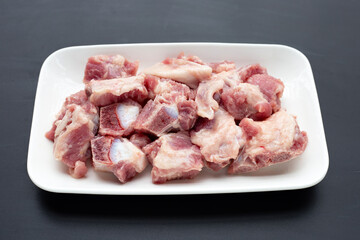 Raw pork ribs in white plate on white background.