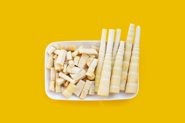 Bamboo shoots in white plate on yellow background.