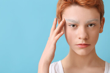 Naklejka premium Teenage boy with dyed eyebrows on color background