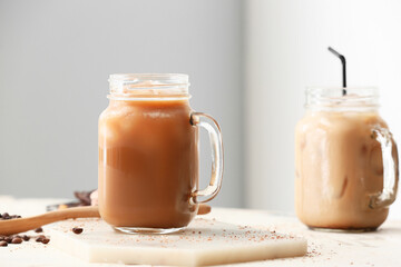 Board with mason jars of tasty iced coffee on table