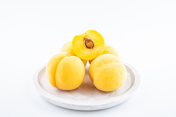 Fresh yellow peaches on white background