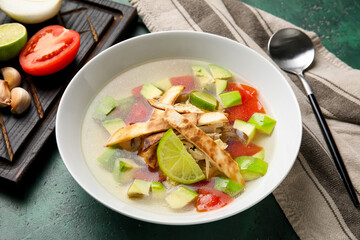 Bowl of tasty Sopa de Lima soup on table
