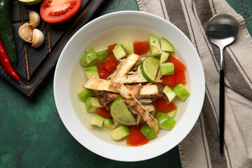 Composition with tasty Sopa de Lima soup on color background