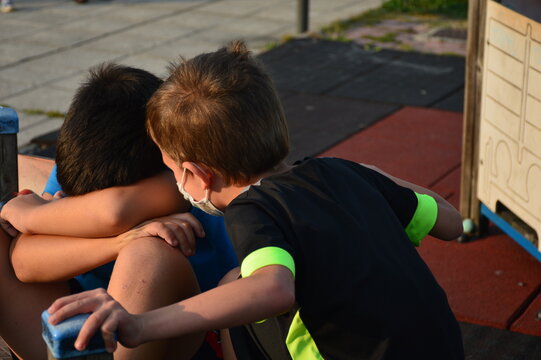 Younger brother comforting his older brother who is sad and crying